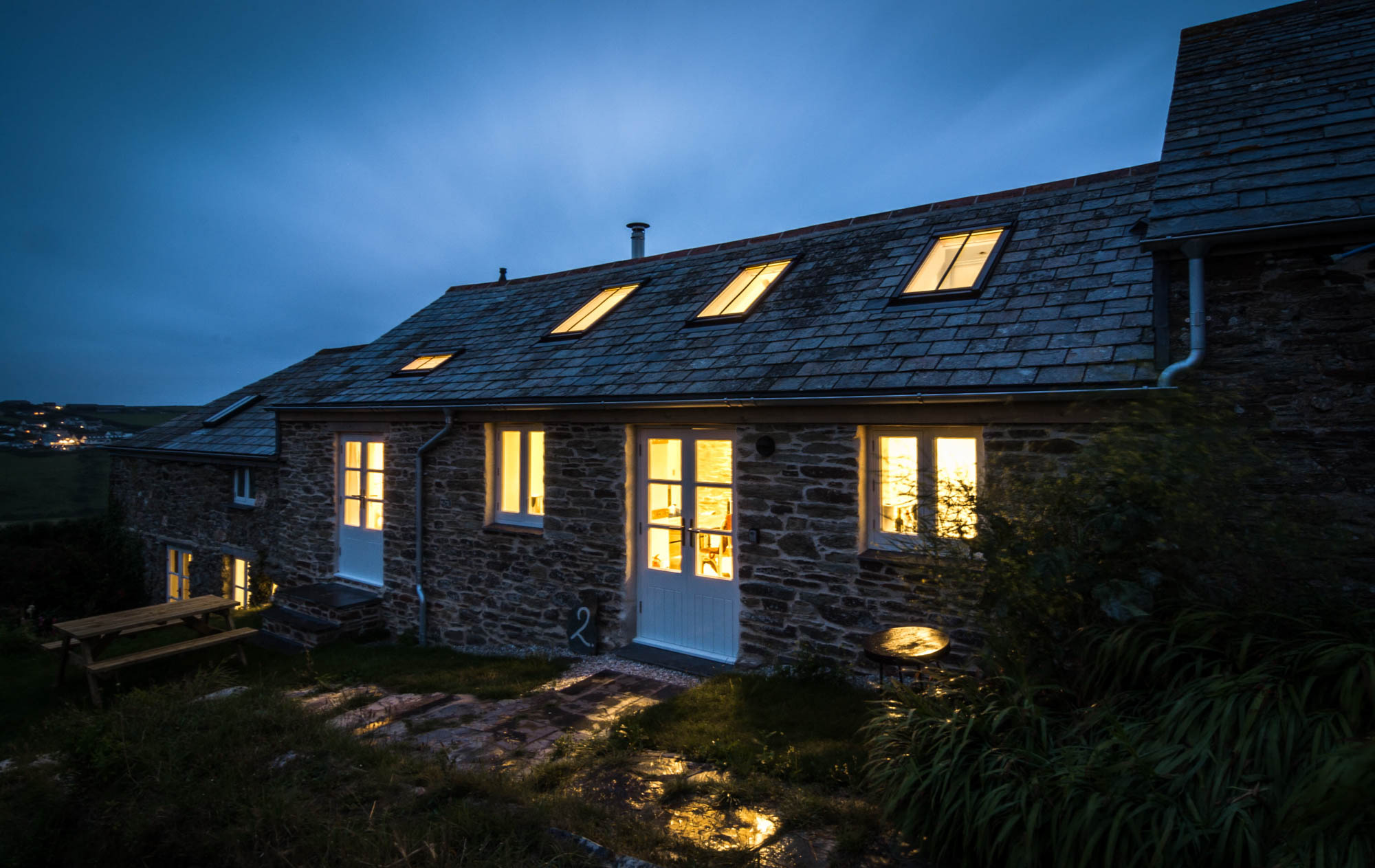 Exterior view of the cottage facade at night showing the new windows.