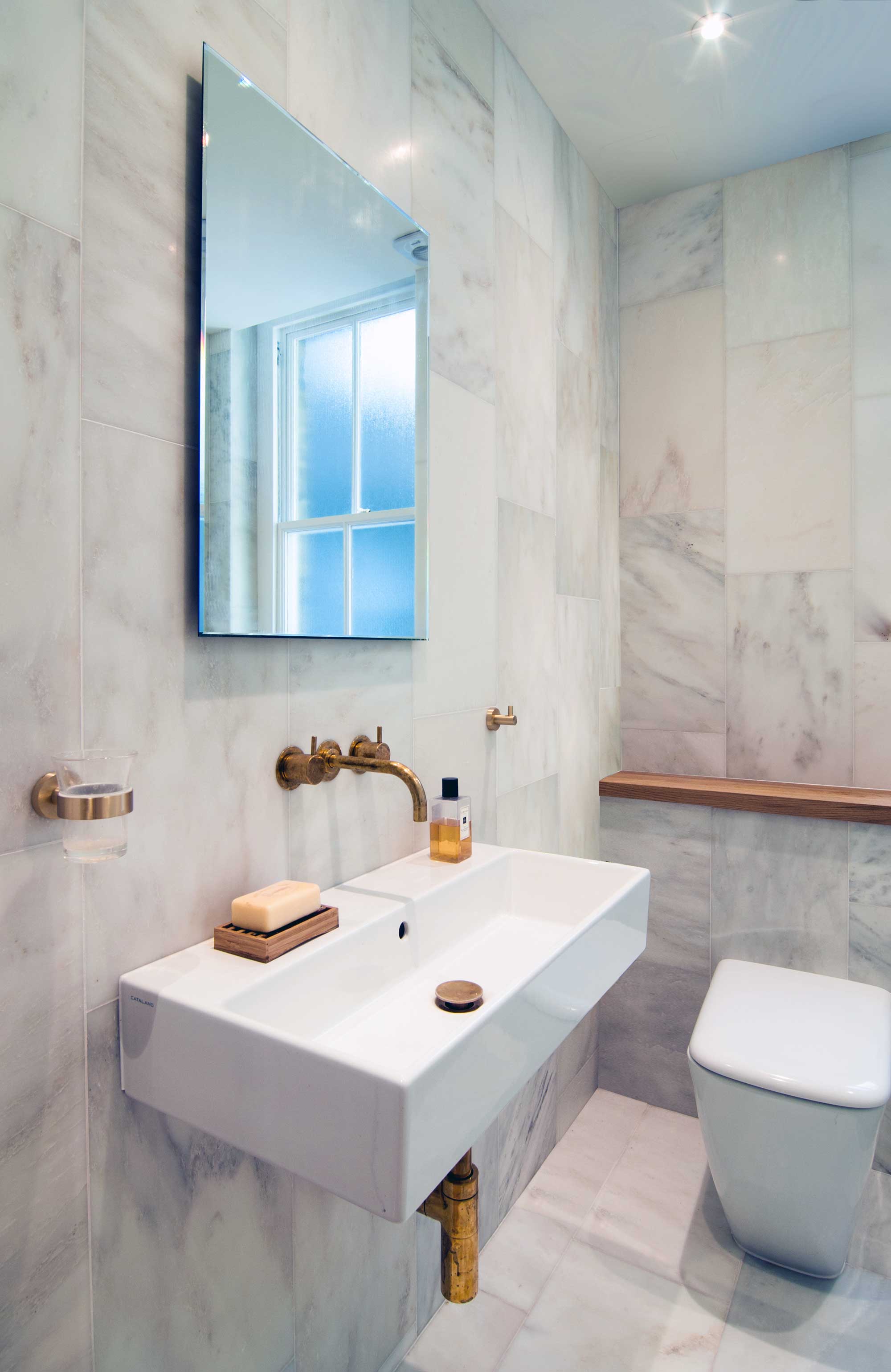Carrara marble tiles on the walls and floor and Vola brass taps are what make this bathroom so unique and original.