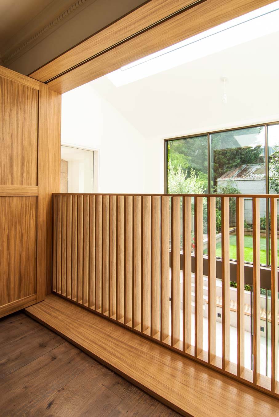 Close up of the Oak shutters balustrade and view onto the extension and sunken courtyard.