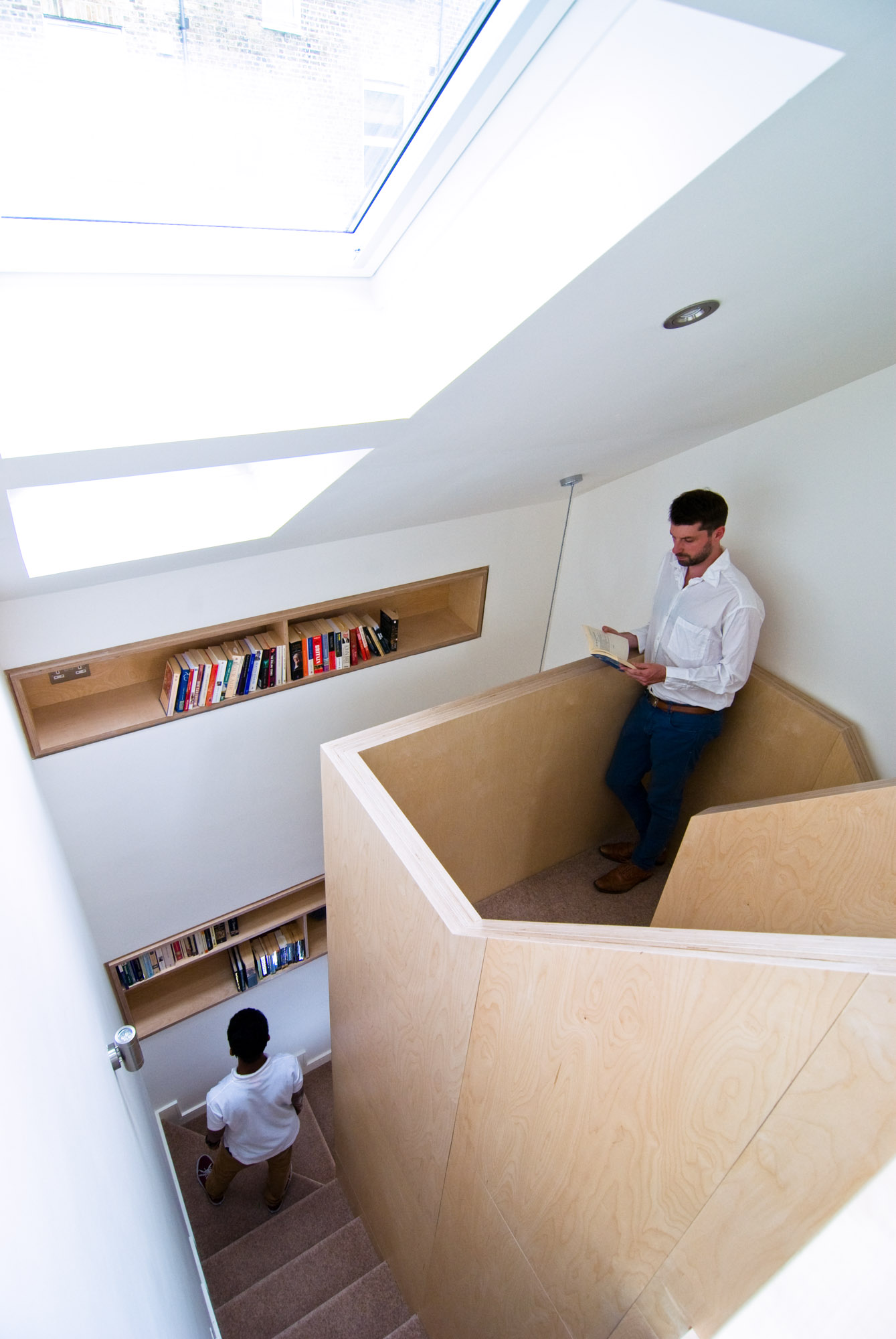 Original plywood staircase with plywood bookshelves incorporated into the walls.