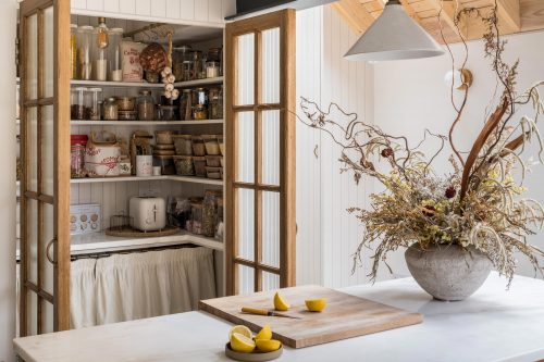 Pantry doors open with lemons being cut on the cutting board