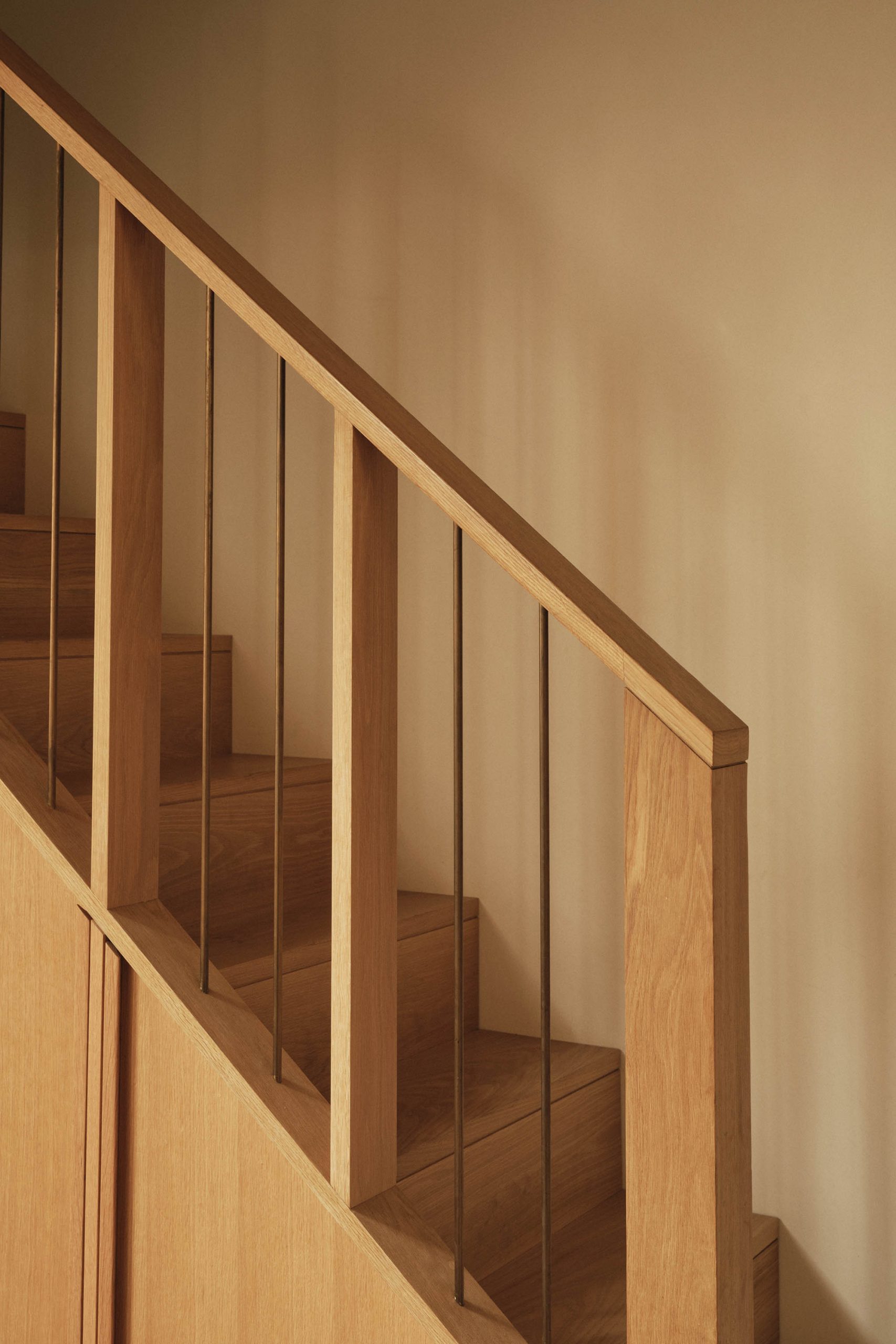 Lauriston staircase with bespoke oak handrail, brass fins, steps, and built-in joinery