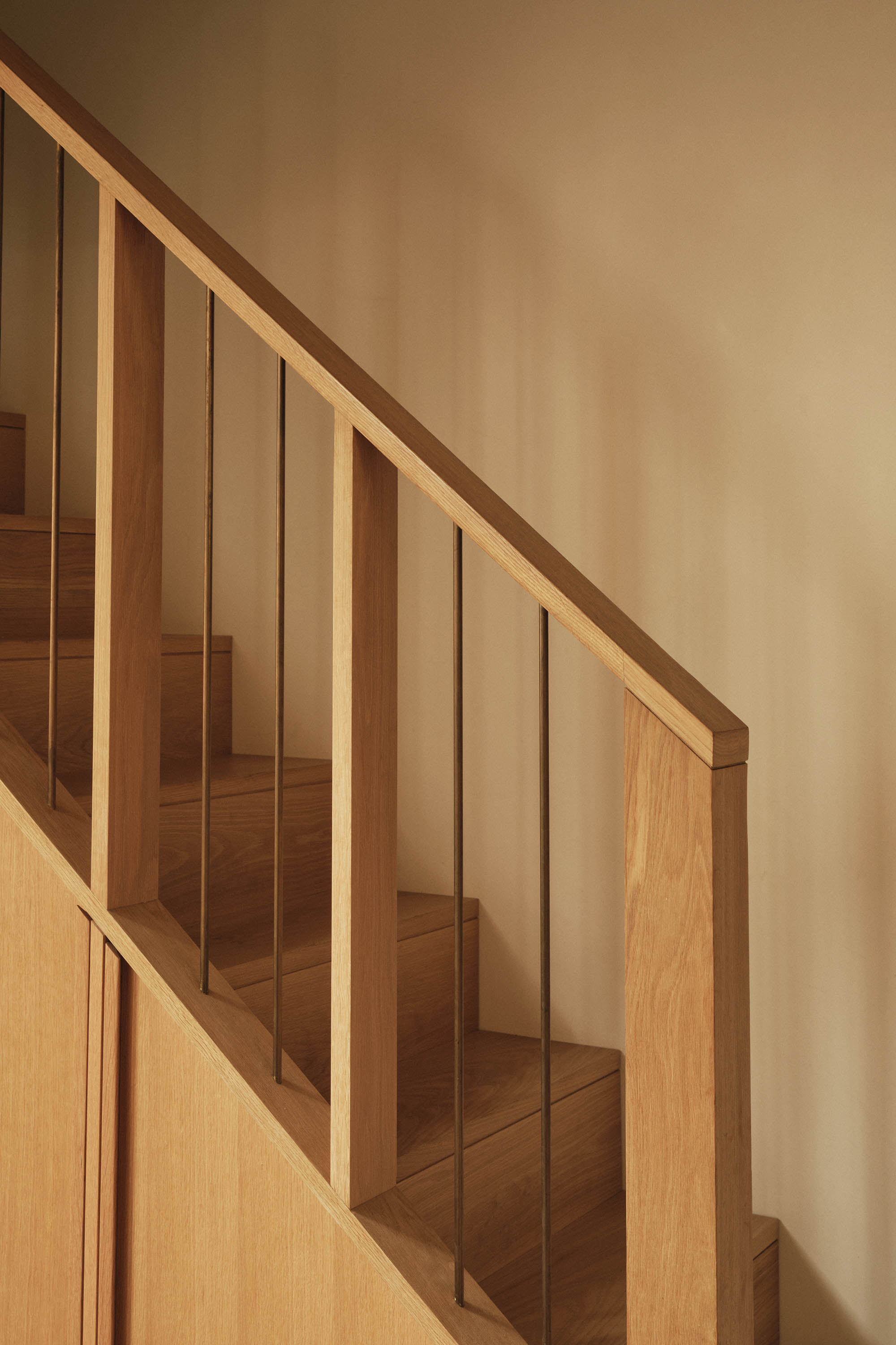 Lauriston staircase with bespoke oak handrail, brass fins, steps, and built-in joinery