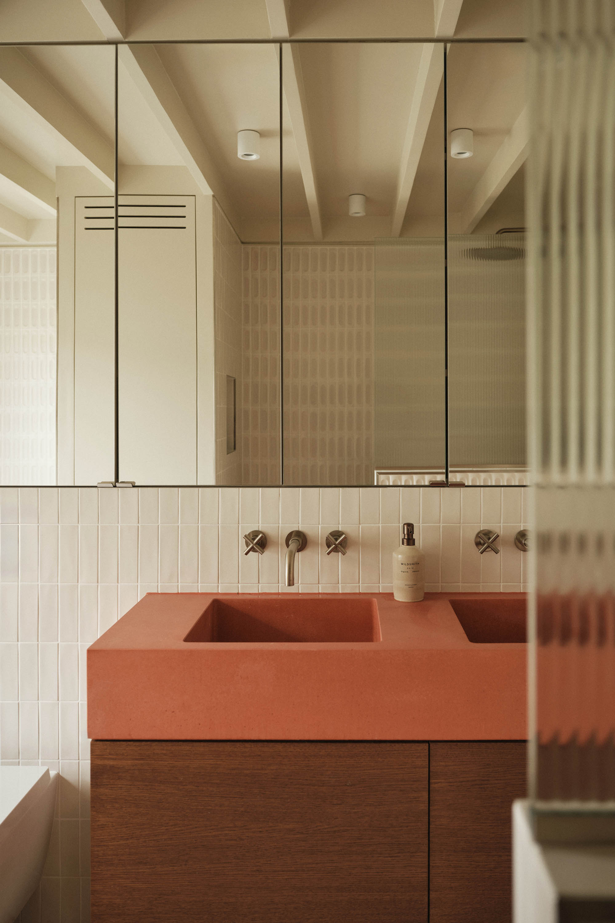 Lauriston bathroom with terrazzo 3D tiles, red concrete sink, oak vanity, built-in bath, exposed joists, painted ceiling, and stainless steel tap