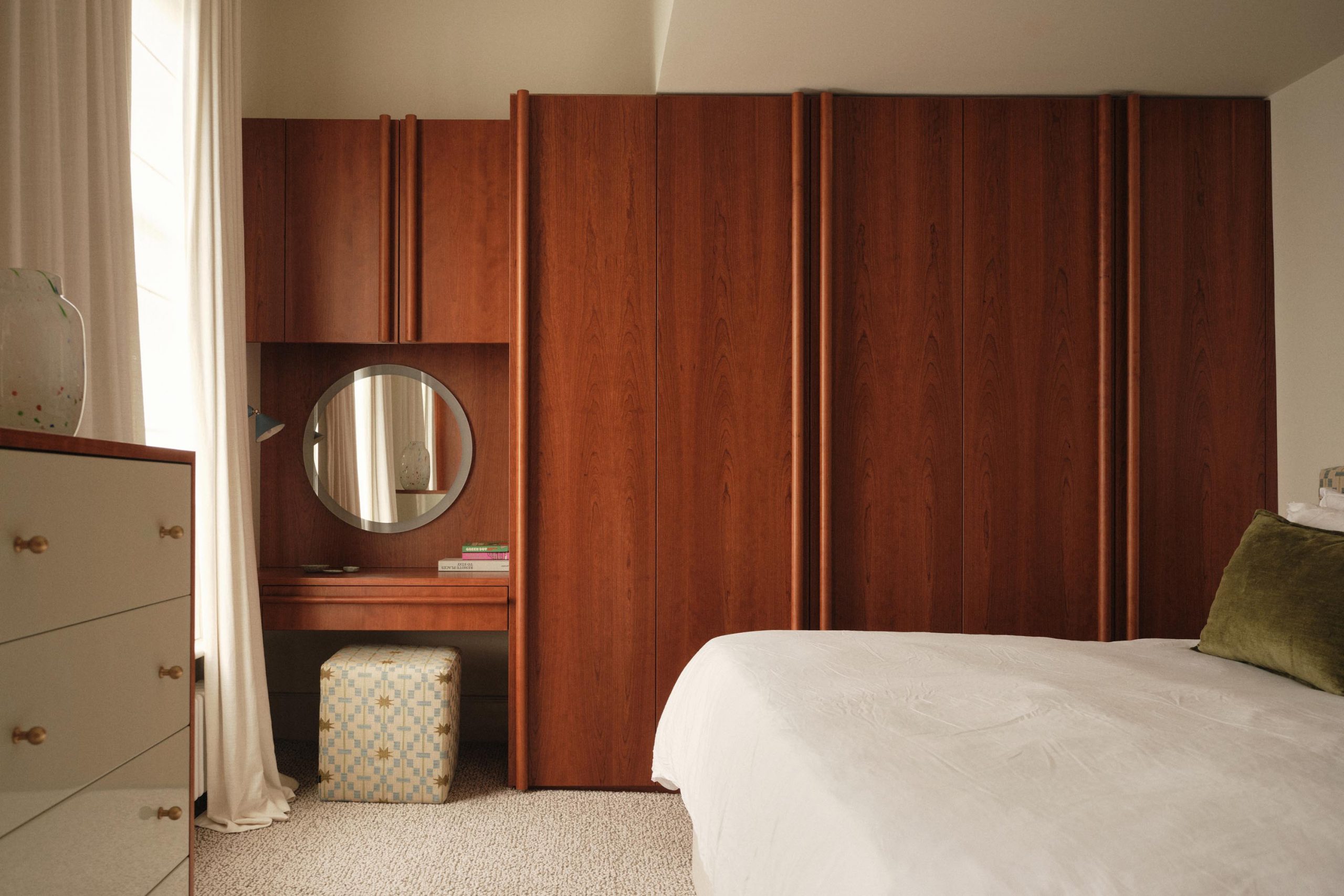 Lauriston bedroom with cherry red stained oak wardrobe, bespoke round handles, and built-in vanity