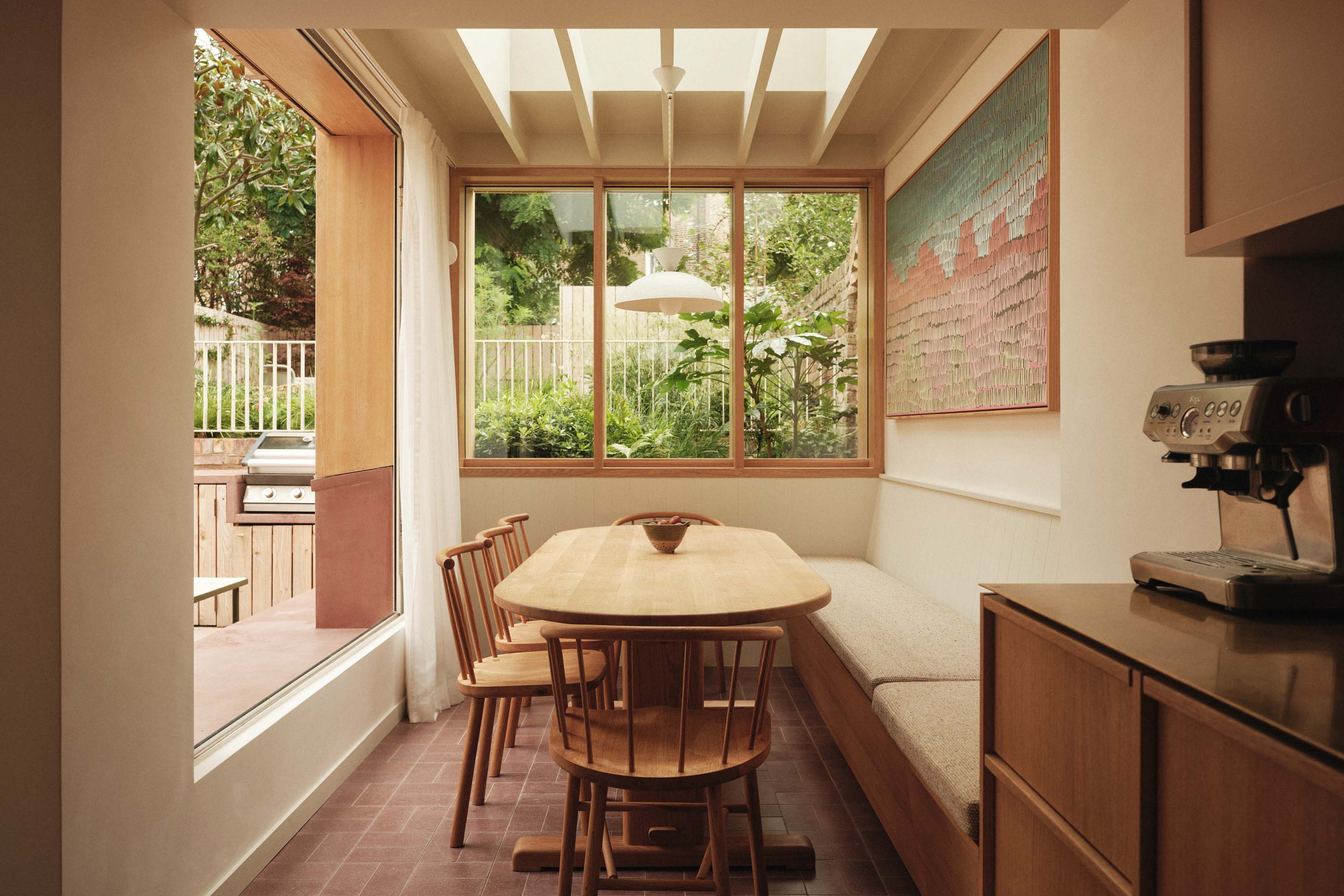 Lauriston dining area with oak table, bench seating, bespoke windows, and red tiled floor