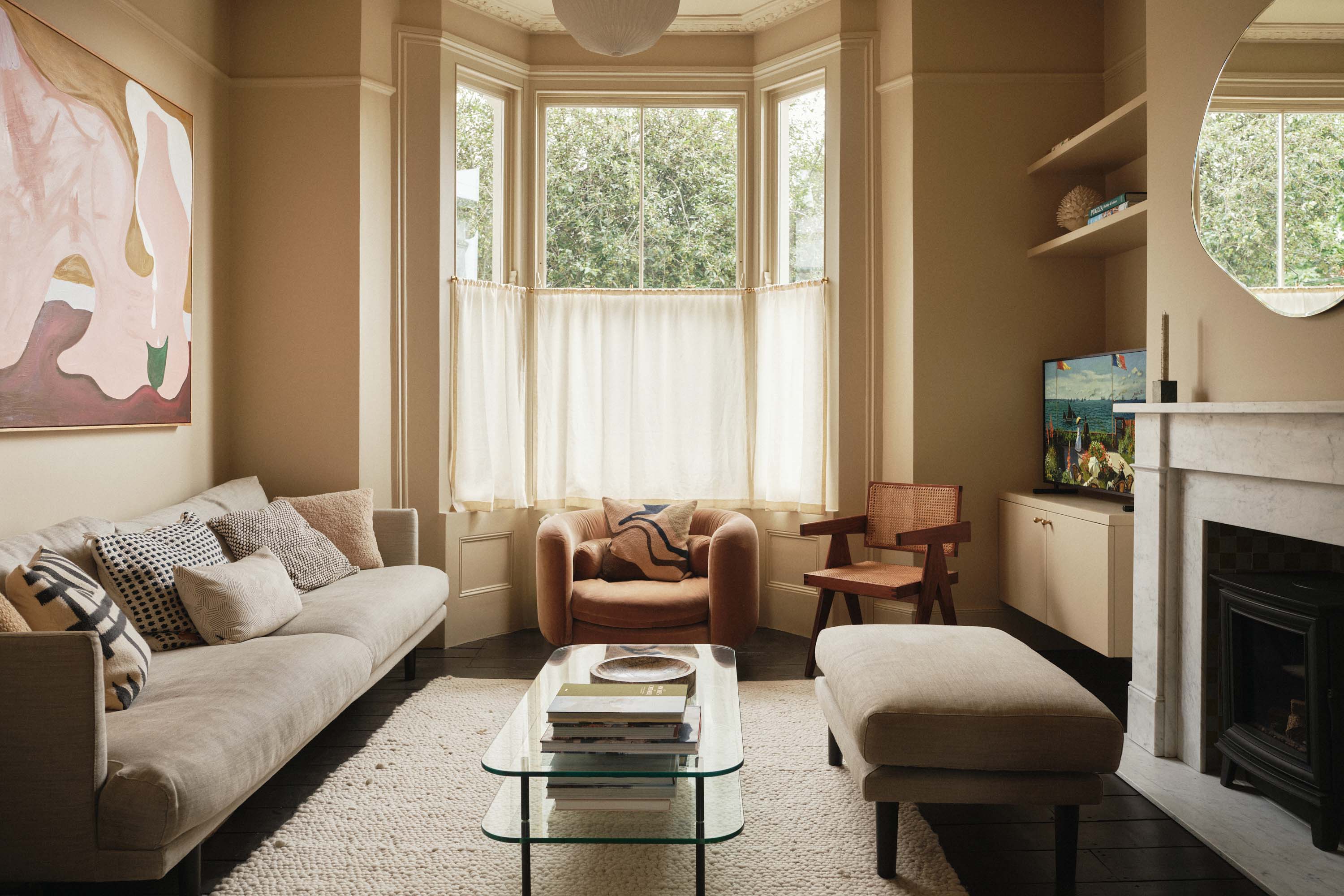 Lauriston snug library with traditional fireplace and woodburner, yellow tiles, coving, modern-coloured sofa, and warm daylight-filled interior