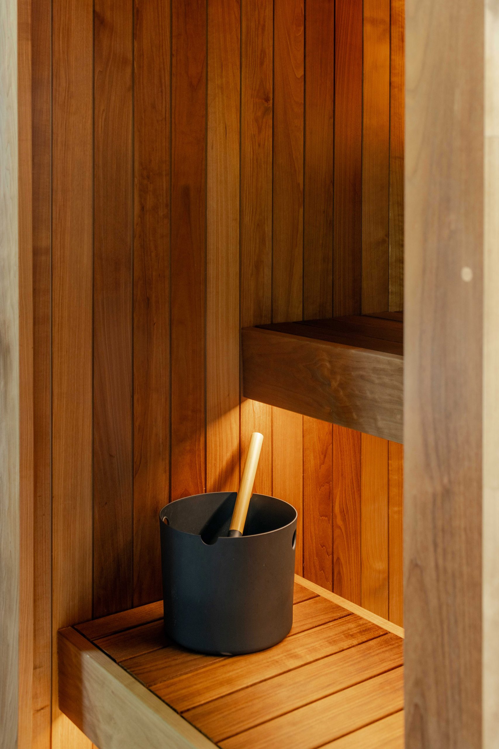 Sauna interior showing timber lining and compact layout and water bucket.