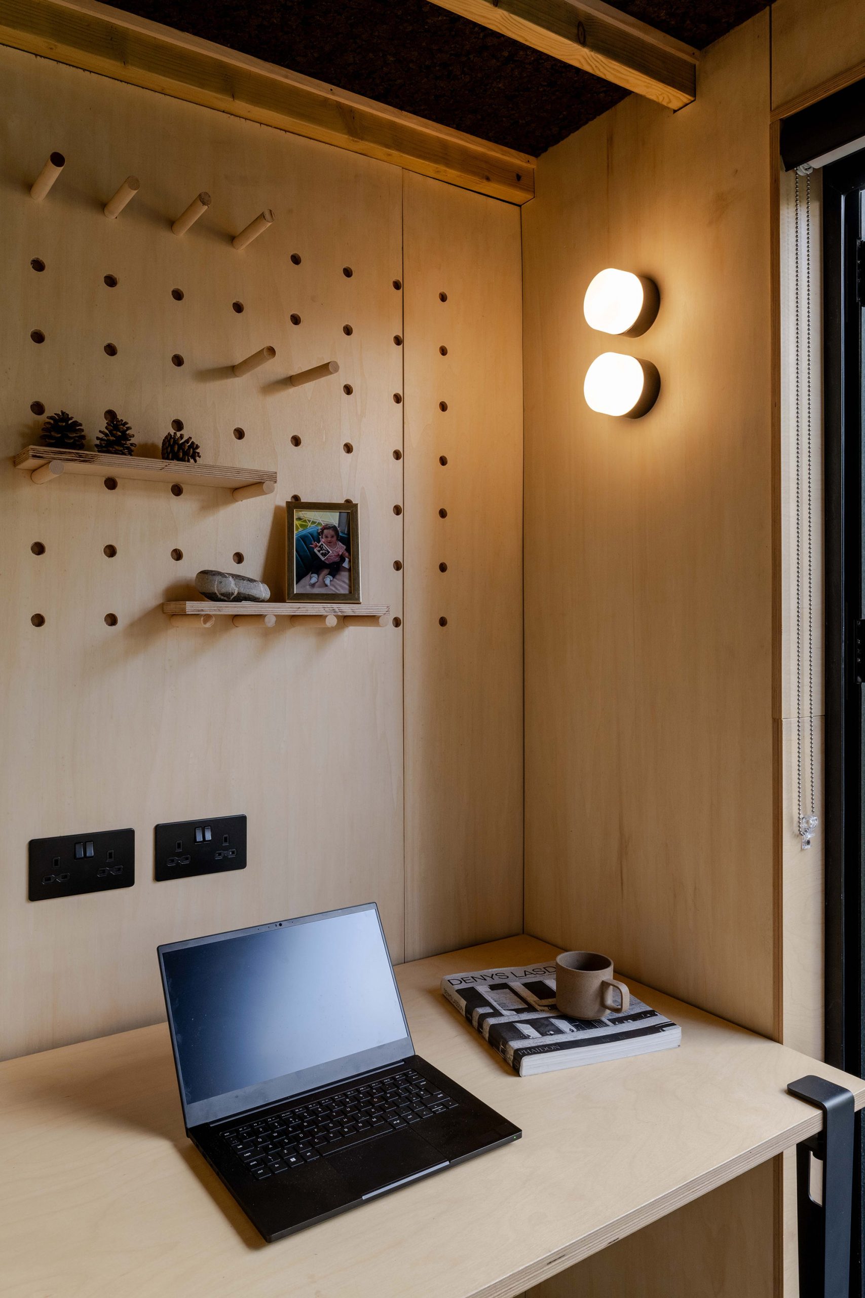 Detail of garden studio workspace with plywood shelf pegs.