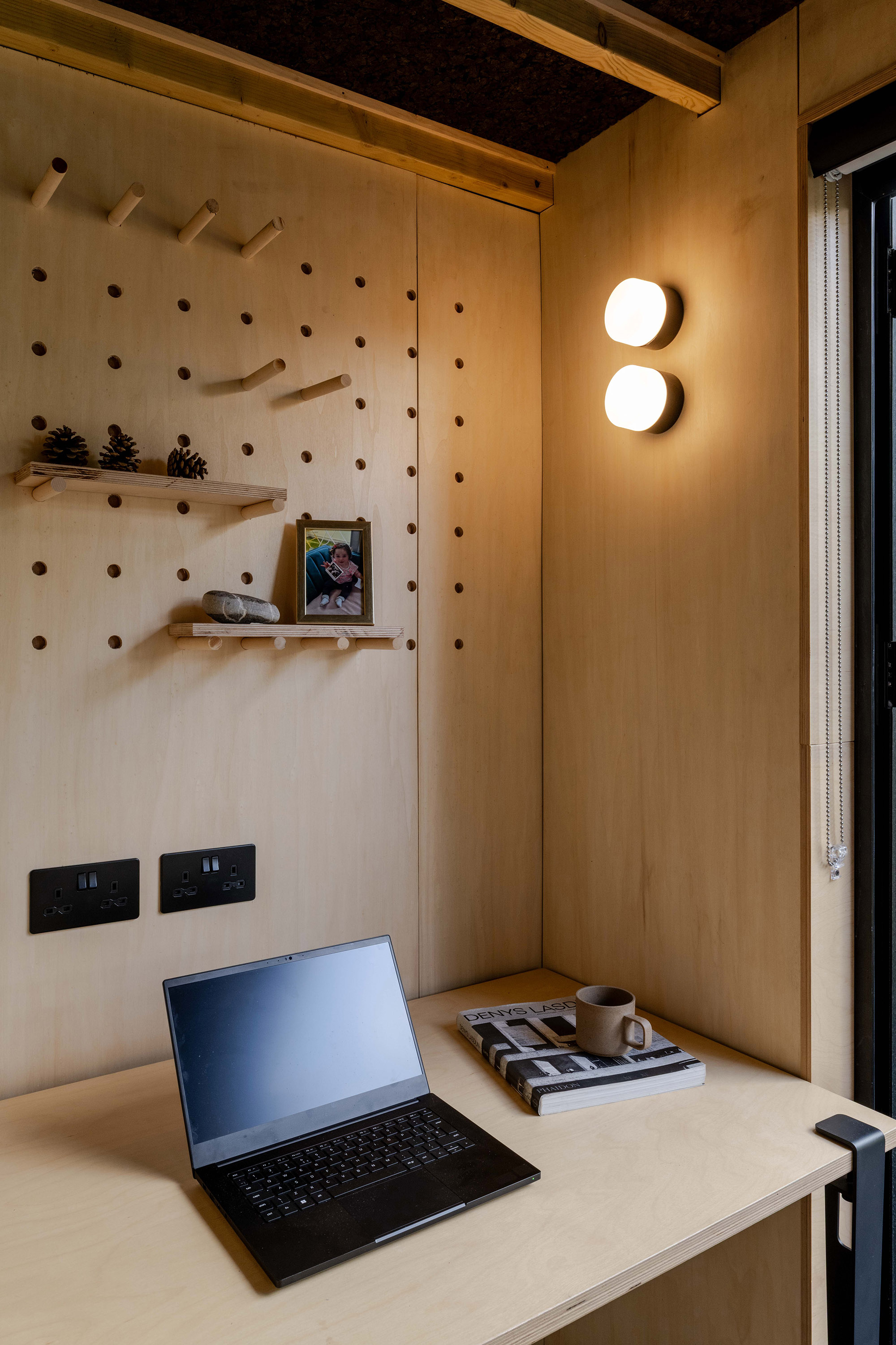 Detail of garden studio workspace with plywood shelf pegs.
