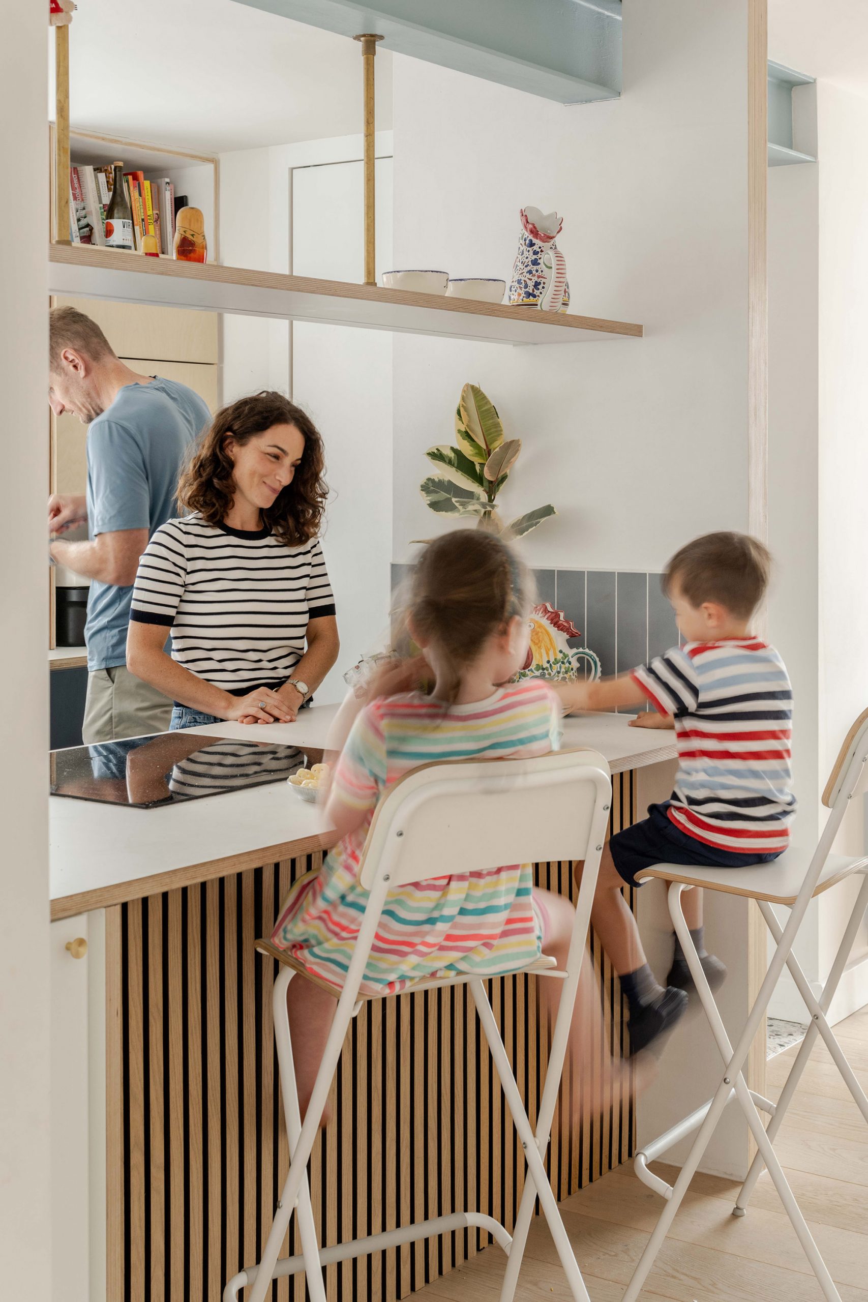 Kitchen island and breakfast bar viewed from the hallway, used as a social and family space.