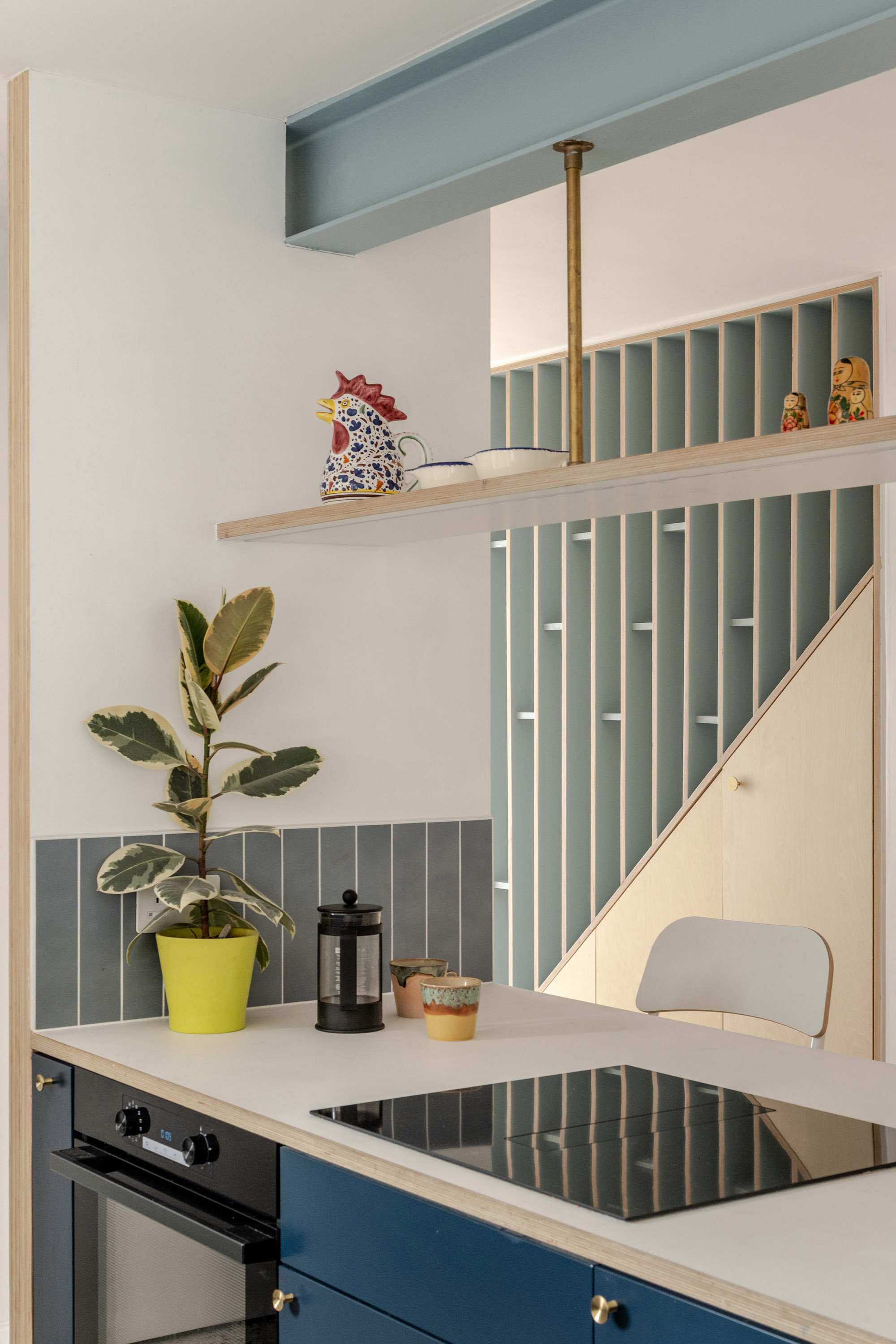 Staircase with vertical plywood balustrade fins and blue accent detailing.
