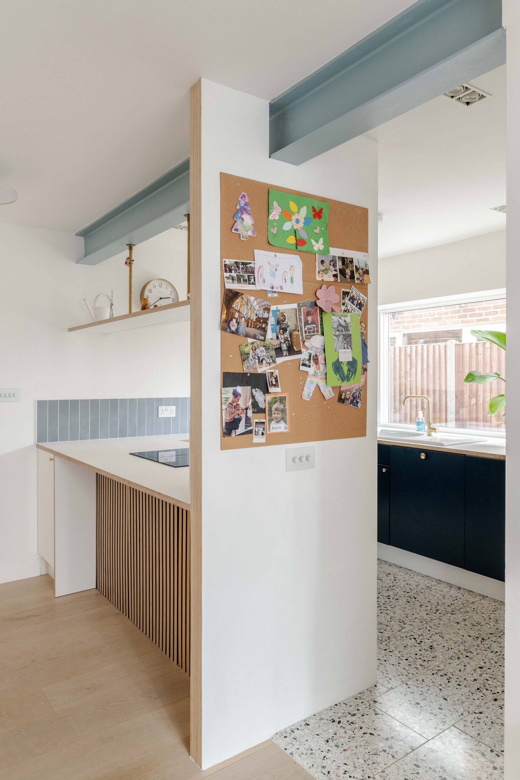 Kitchen island with short stud wall forming a visual screen between hallway and kitchen.