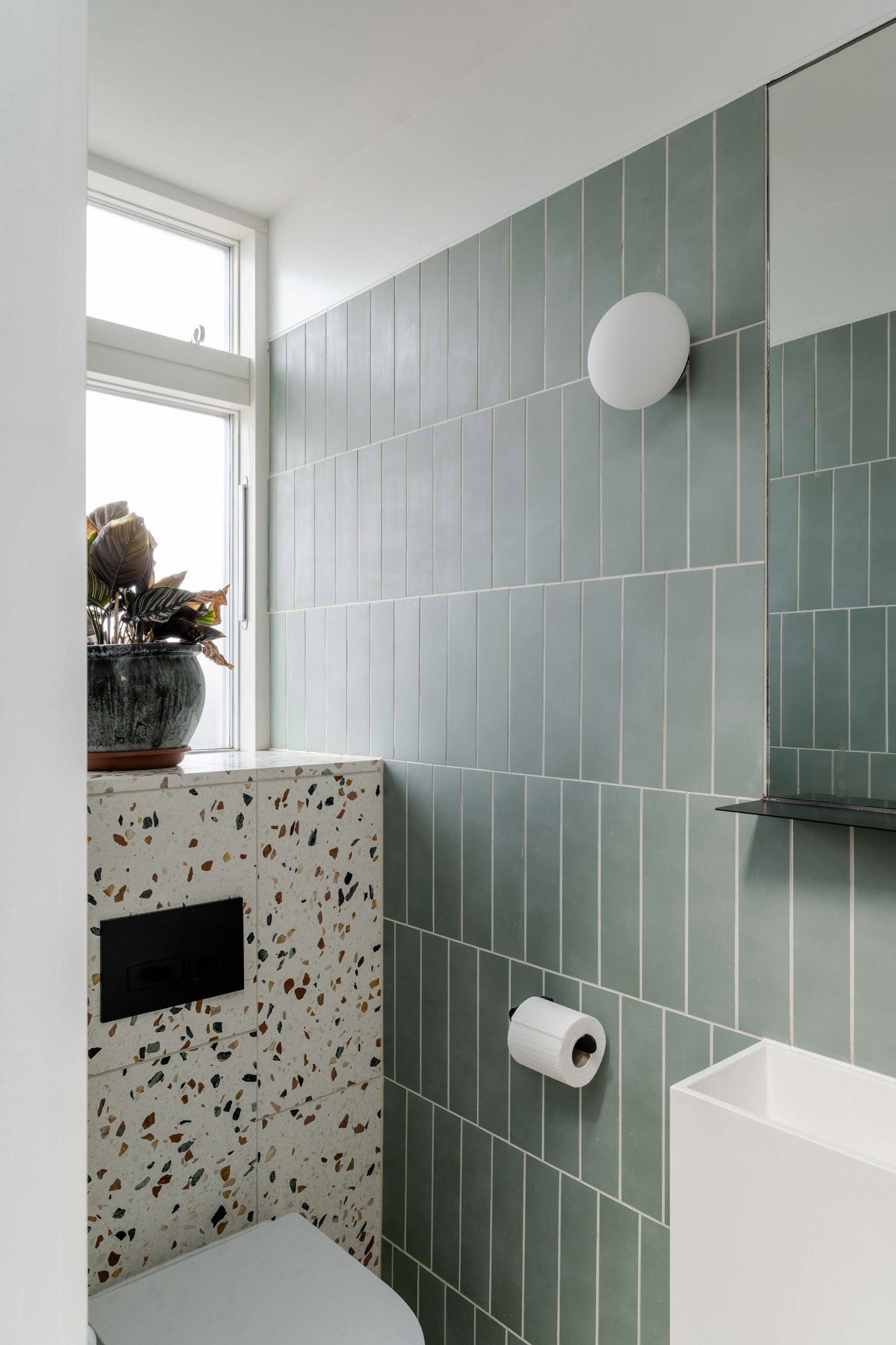 Downstair shower roll with terrazzo and blue tiling.