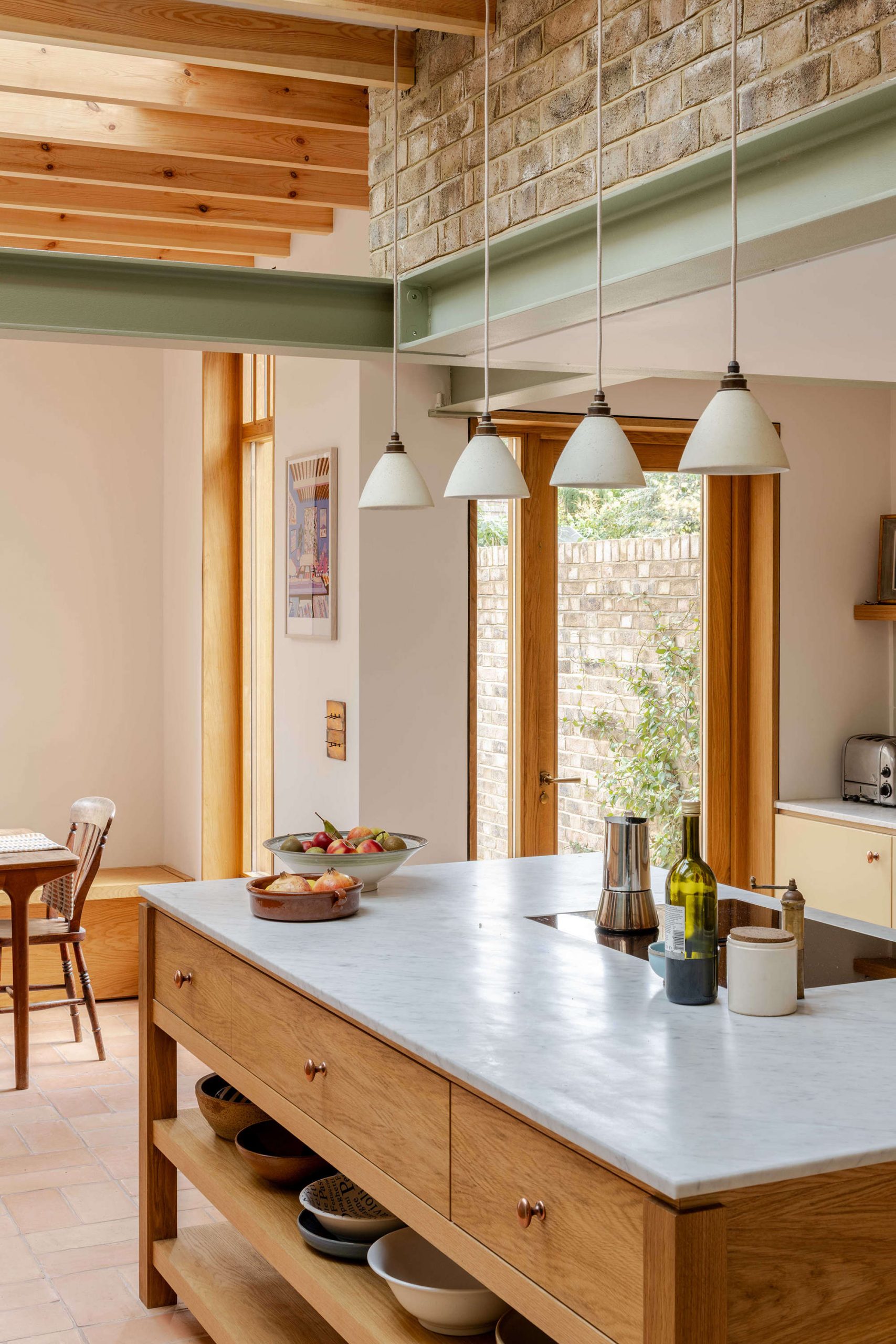 Terracotta floor kitchen with bespoke joinery in a London residential extension designed by Bradley Van Der Straeten Architects.