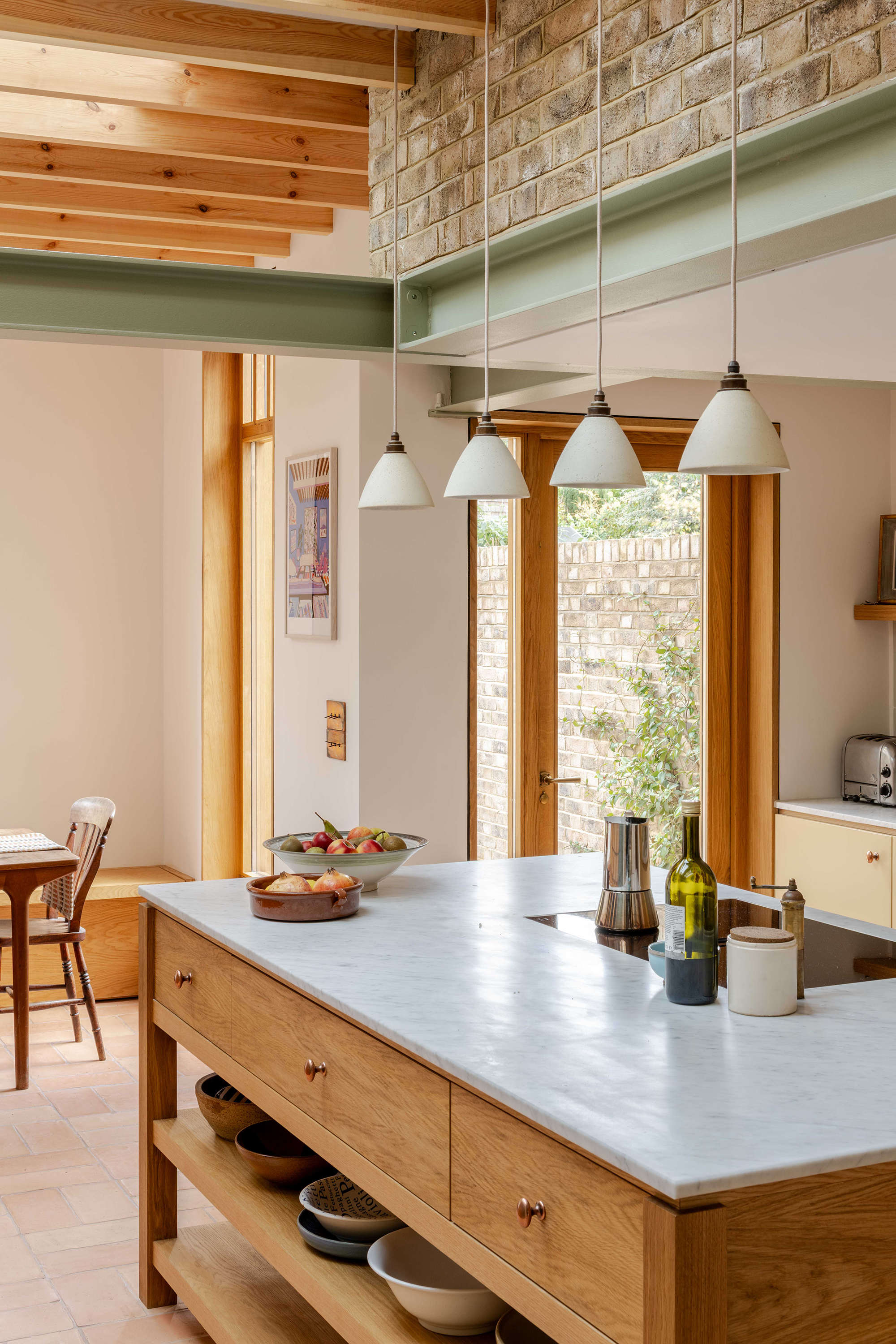 Terracotta floor kitchen with bespoke joinery in a London residential extension designed by Bradley Van Der Straeten Architects.