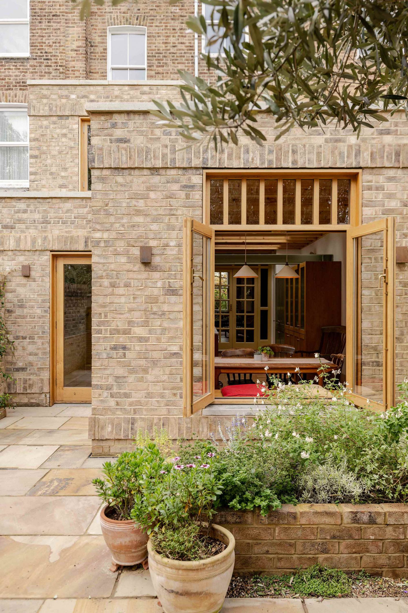 Contemporary rear addition to a Victorian terrace in North London by Bradley Van Der Straeten Architects with reclaimed brick and timber joinery.