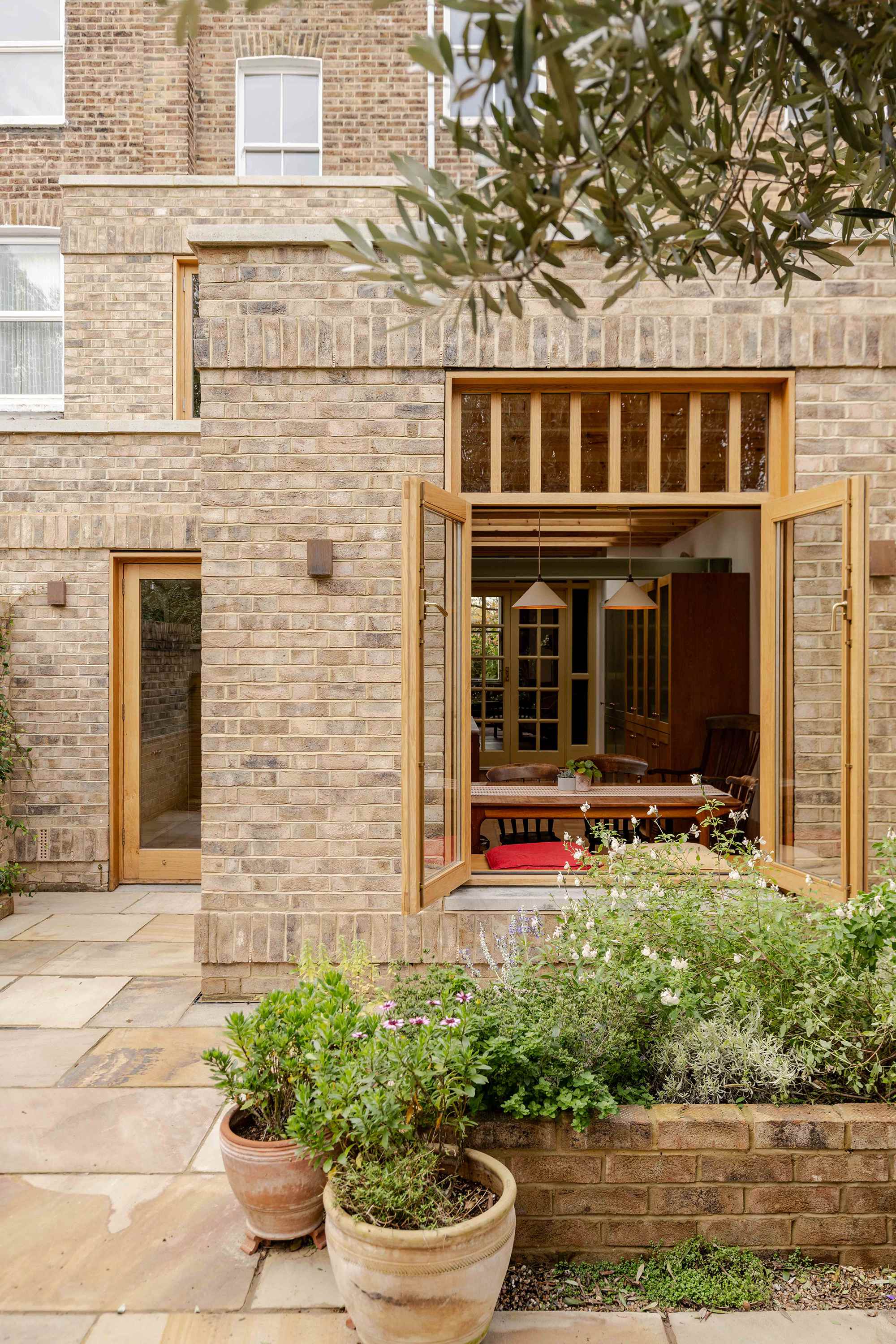 Contemporary rear addition to a Victorian terrace in North London by Bradley Van Der Straeten Architects with reclaimed brick and timber joinery.