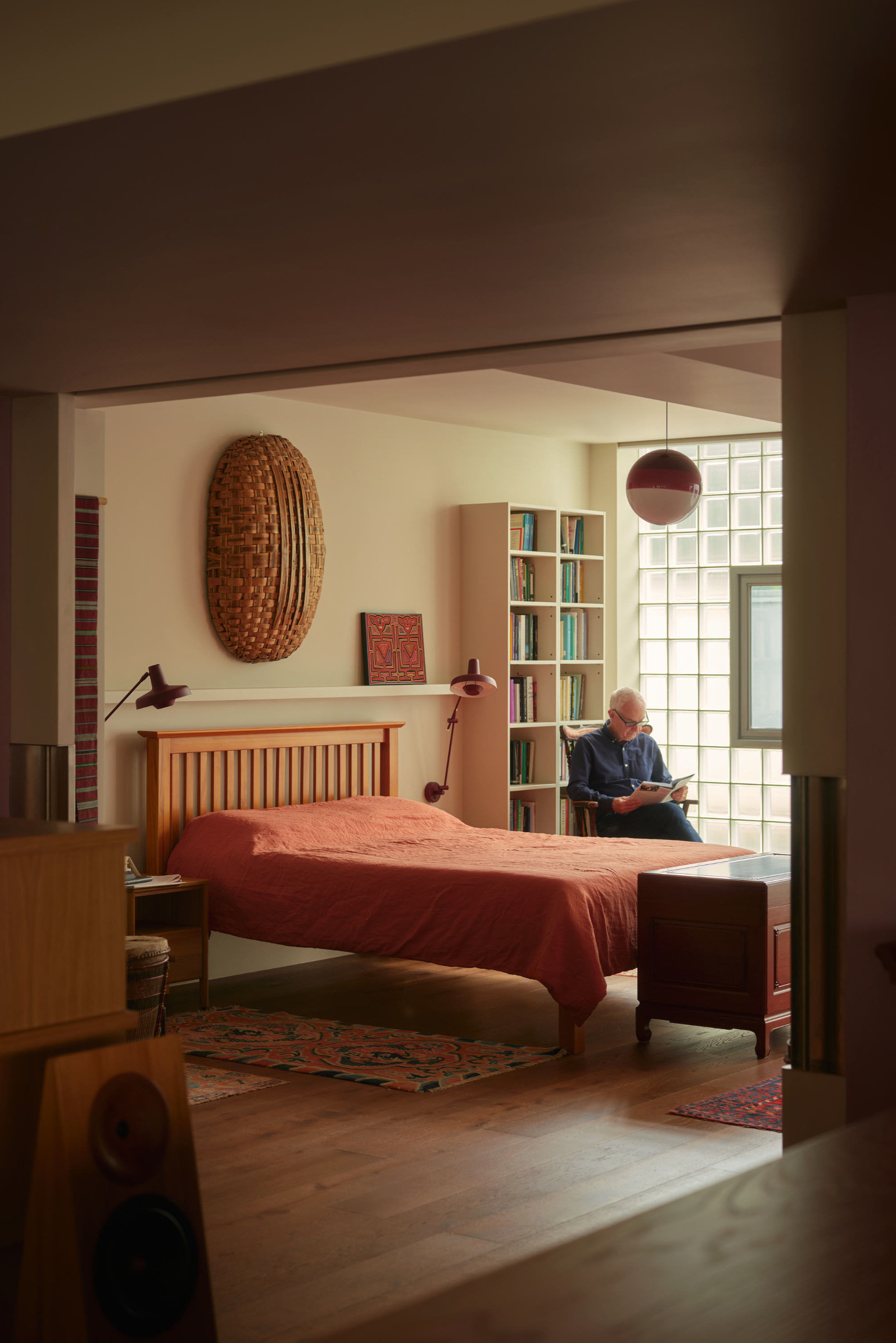 Bedroom extension with render walls and gridded windows creates open plan living space.