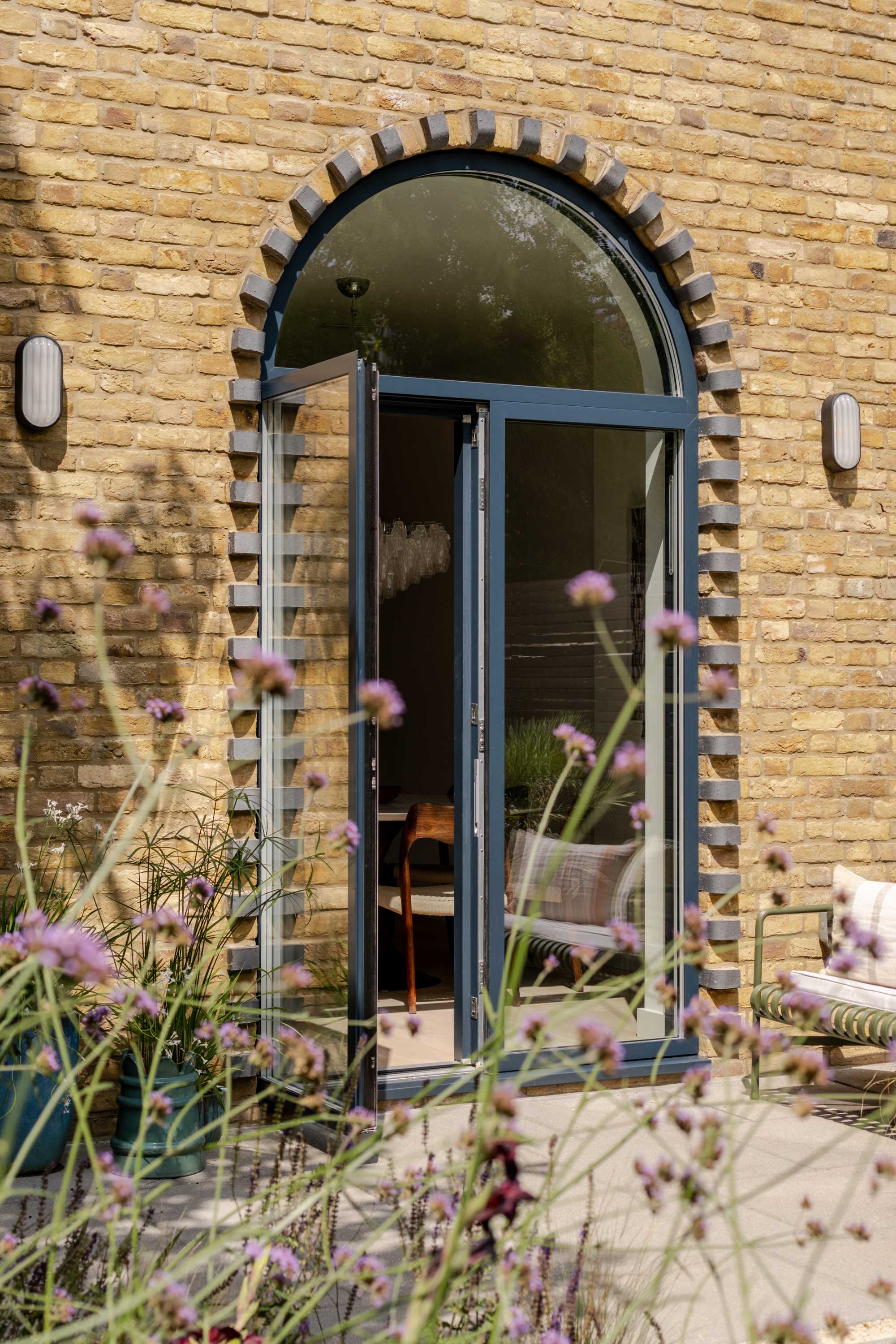 Arched brick rear extension with large glazed doors and transom window creating bright open plan living space.