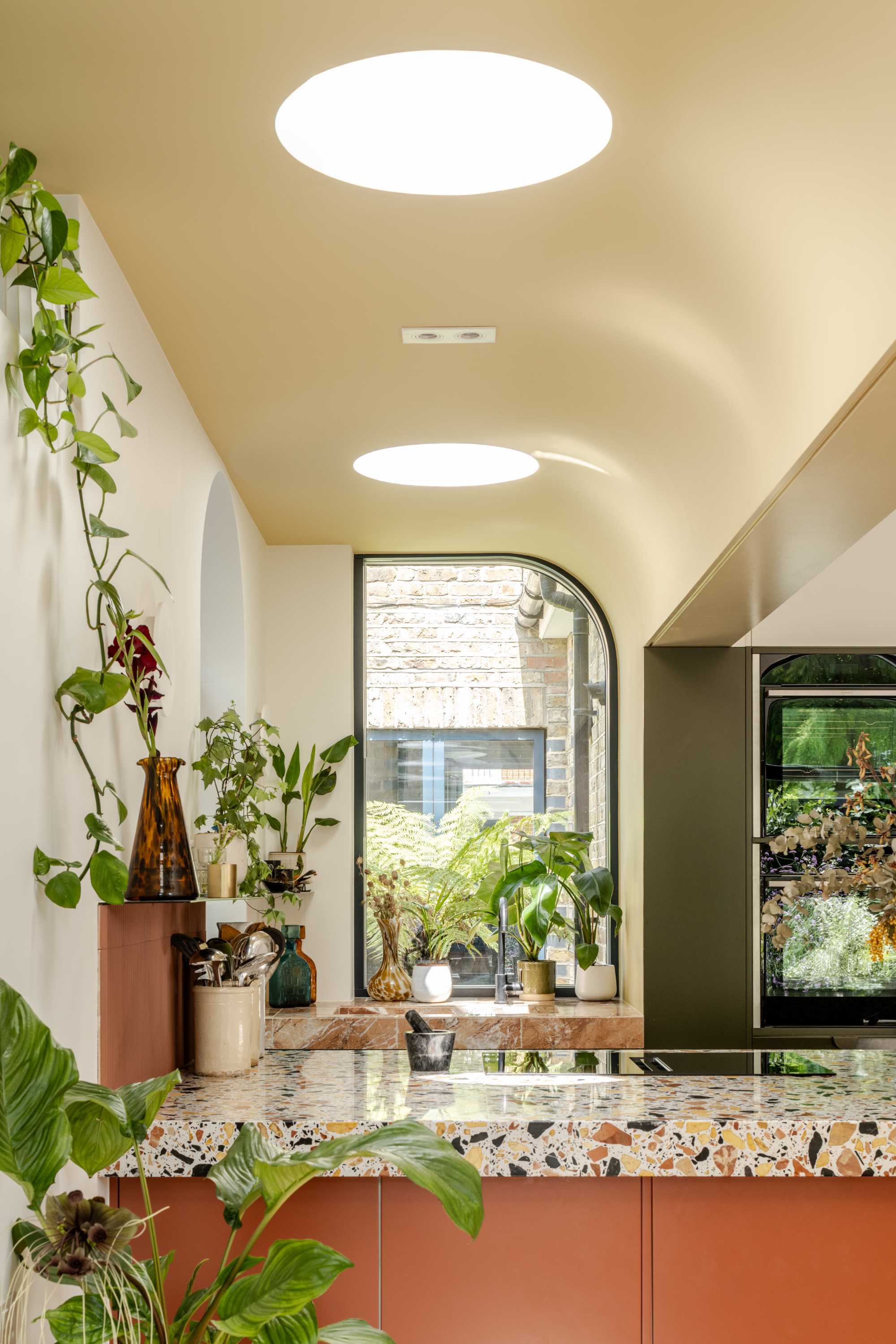 Modern kitchen extension with cream render, terrazzo countertops, and recessed skylights. Open plan living with garden views.